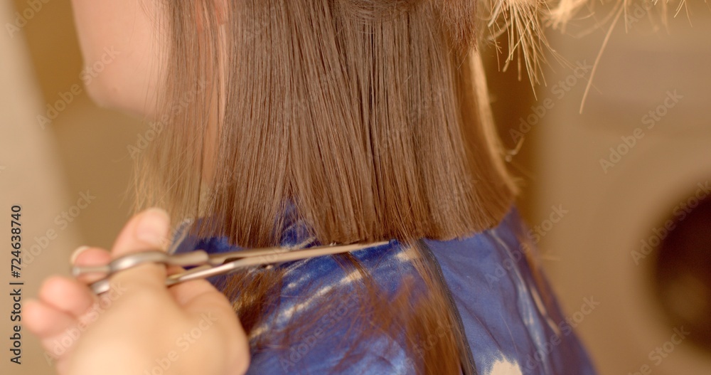 Obraz premium Beauty routines and haircare. Personal care close-up video capturing woman's routine grooming session. Scissors delicately trim woman damaged split ends of her hair, details in hairstyling.