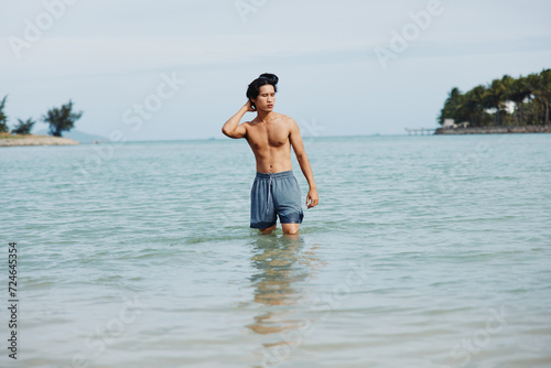 Smiling Asian Man Enjoying Fun and Freedom in Tropical Water