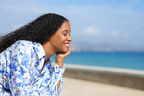 Happy black woman smiling and relaxing on the beach