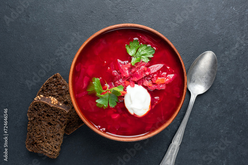 Red beet vegetarian soup Borscht served with sour cream in ceramic bowl, table top view
