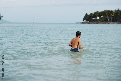 Swimming Man in Tropical Water: Vacation Bliss and Summer Fun with Asian Influence