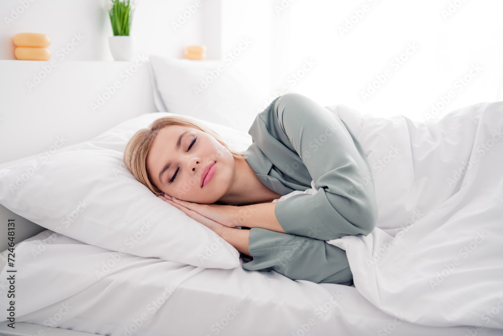 Photo portrait of pretty blonde young girl lying bed hands closed eyes together wear trendy gray nightwear bright bedroom interior design Photo portrait of pretty blonde young girl lying bed hands closed eyes together wear trendy gray nightwear bright bedroom interior design