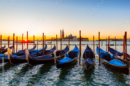 Gondolas moored by Saint Mark square against San Giorgio di Maggiore church in Venice, Italy. © preto_perola