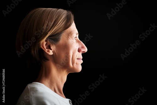 profile of a person with a dismal backdrop, only face lit photo