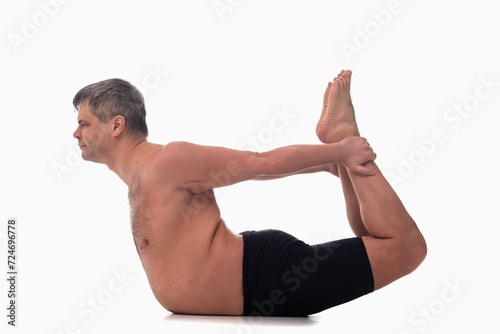 Dhanurasana, Ashtanga yoga Side view of man wearing sportswear doing Yoga exercise against white background.