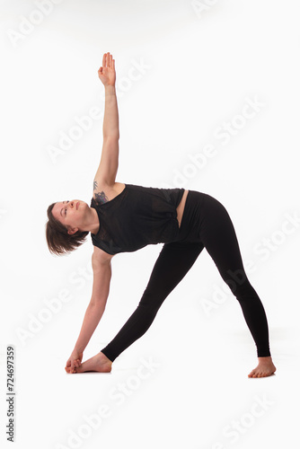 Utthita trikonasana, Ashtanga yoga Side view of woman wearing sportswear doing Yoga exercise against white background.