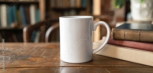 Empty white mug on a table with earth-toned books, close-up angle.