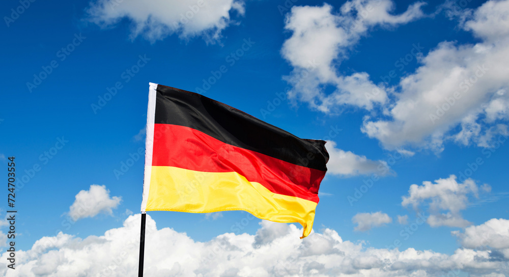 Naklejka premium German flag waving against blue sky