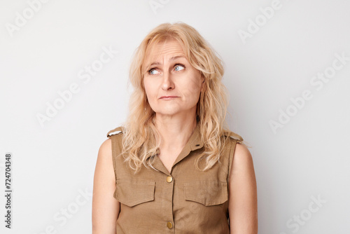 Portrait of adult woman with sad face offended and crying on white background. Nerves, stress, uncertainty concept.