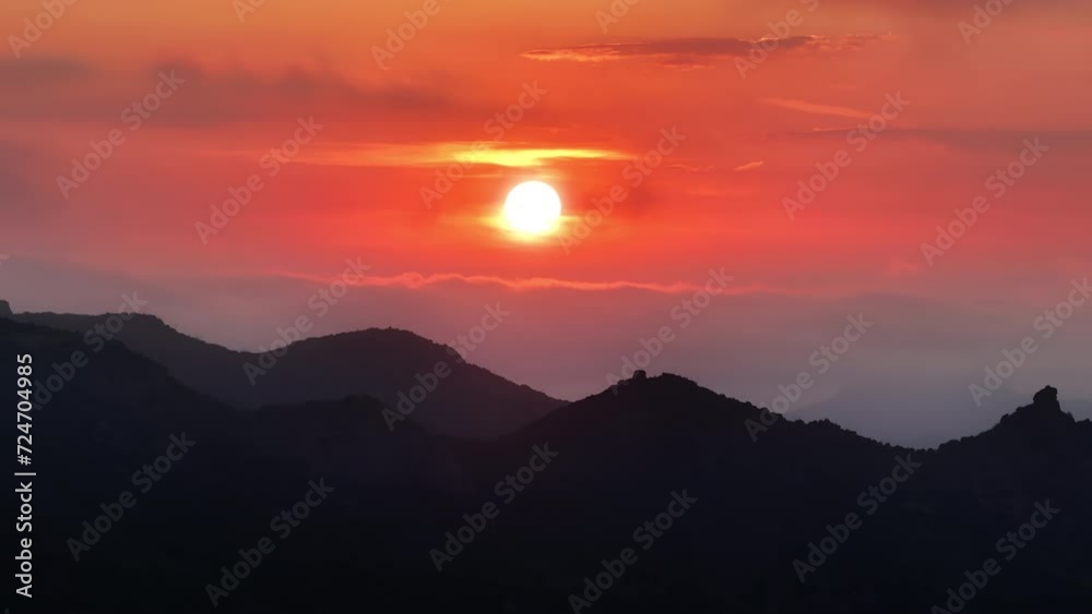 Aerial view of sky in sunset colors over Malibu mountains, Los Angeles suburban, California, USA. Breathtaking sunrise view. Birds eye view of rocky hills touching the sky, 4k footage with copy space