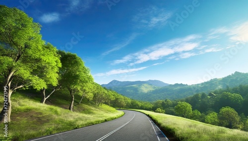 a winding road stretching ahead flanked by verdant trees and hills under the clear blue sky