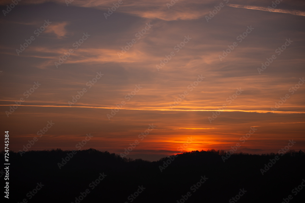Orange solar disk seen above the forest. Wonderful sunset at the end of day Orange solar disk seen above the forest. Wonderful sunset at the end of day