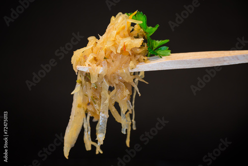 cabbage stewed with spices and carrots on a wooden fork