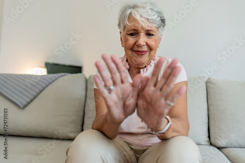 happy senior old hoary woman touching wrist joint, suffering from injured hand. Frustrated stressed middle aged mature female retiree having painful feelings in bones, arthritis osteoporosis concept.