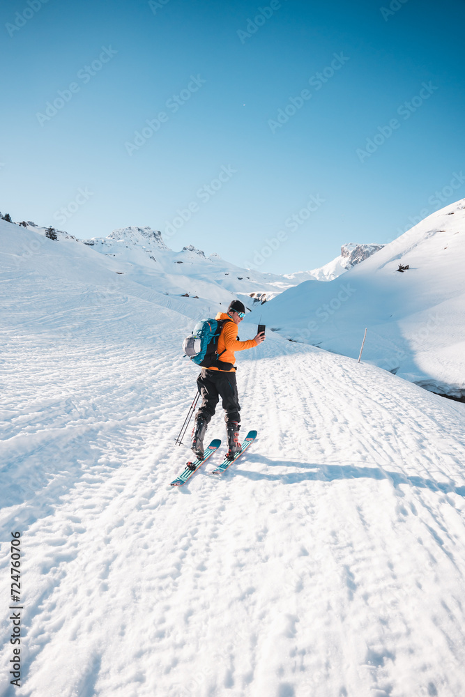  A man on ski alpine tour throught snowy Alps in Switzerland or Austria, Backcountry skier in Alps