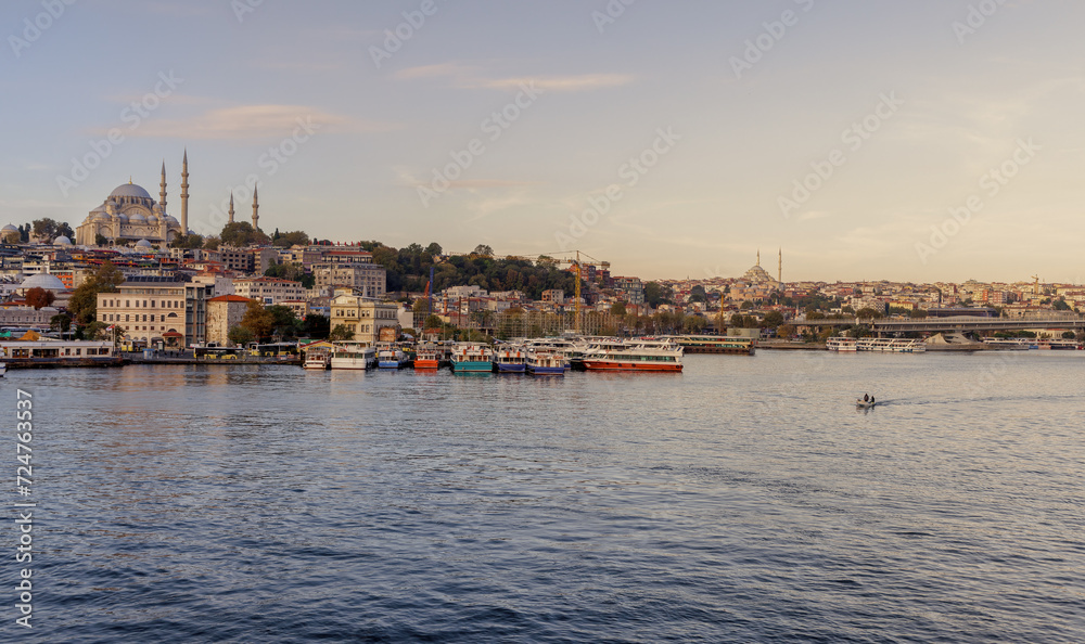 Istanbul, Turkey - 09.10.2022: View of the embankment, water and ships in the city of Istanbul on a summer day. Big ferry ship sail at Bosphorus strait, mosques of Fatih area seen on back.