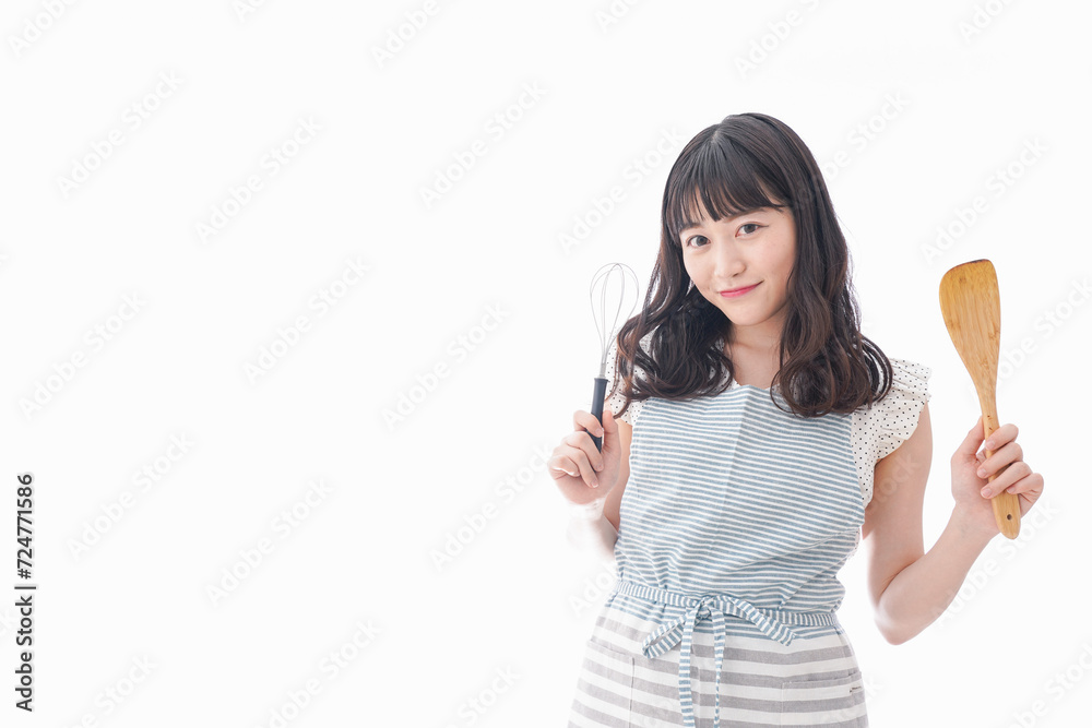 エプロンを着てごはんを作る若い女性 エプロンを着てごはんを作る若い女性