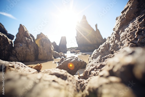 sun spots seen through craggy rocks on a coastline photo