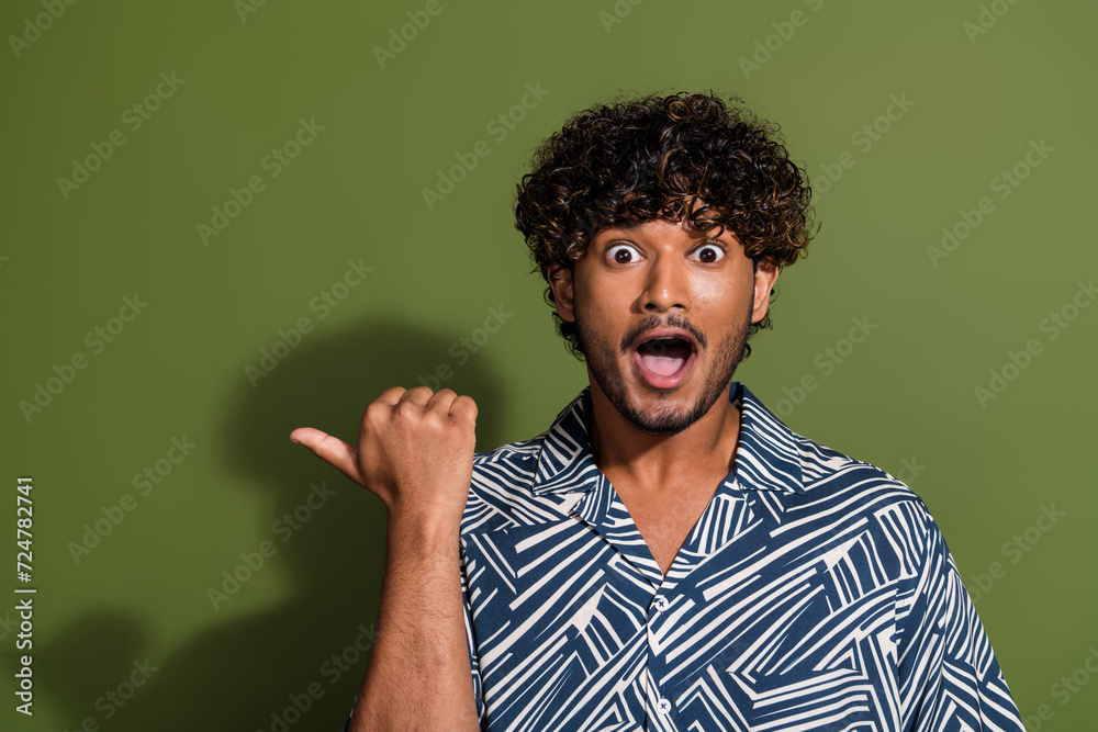 Portrait photo of amazed young mexican funny guy in shirt open mouth direct finger mockup unexpected isolated on khaki color background Portrait photo of amazed young mexican funny guy in shirt open mouth direct finger mockup unexpected isolated on khaki color background