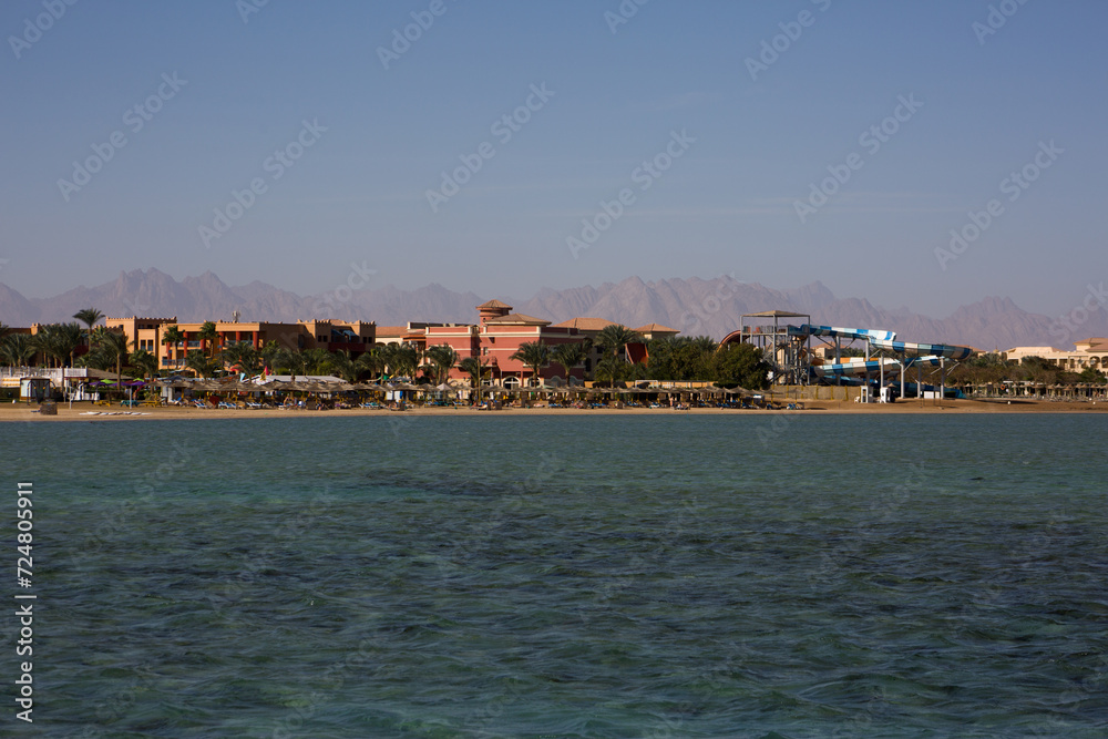 Sandy beach of Hurghada overlooking the hotel on the first line of the sea. Relaxing on a sandy beach in summer under the lightning, view from the Red Sea