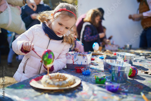 Fotografie Adorable preschooler girl making diy Easter craft outdoors
