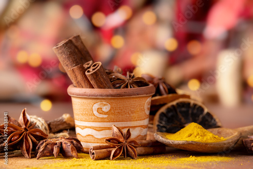 various spices and dried orange slices, lights on bokeh background. Still life