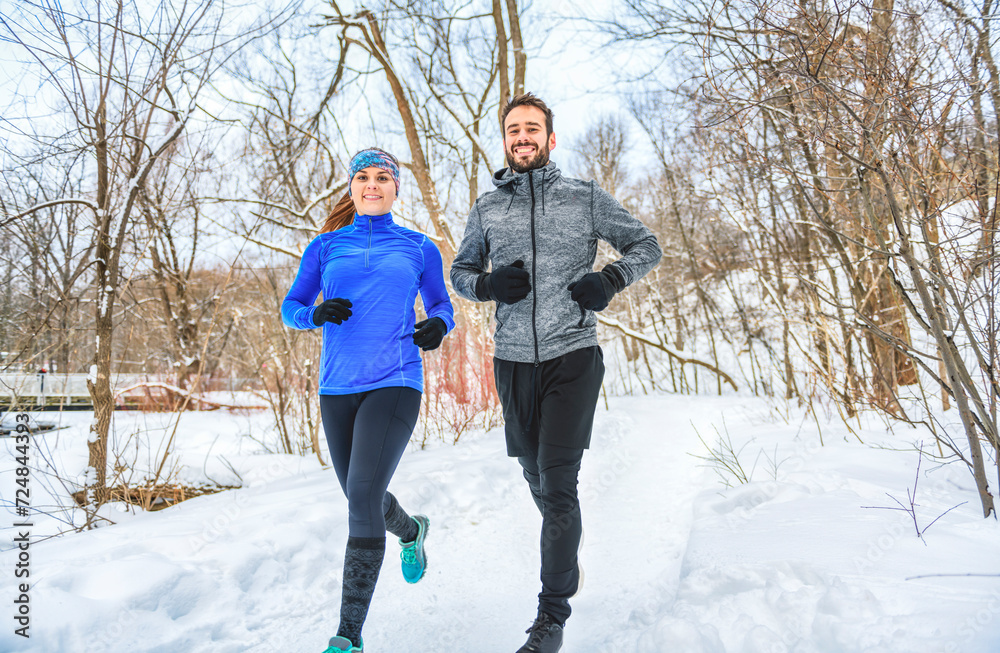 active runner couple jogging together in forest active runner couple jogging together in forest