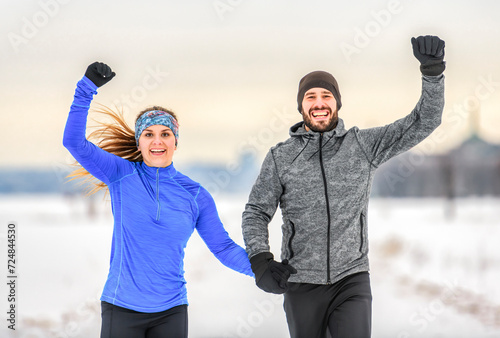 Fototapeta Naklejka Na Ścianę i Meble -  active runner couple jogging together in snowy path in nature.