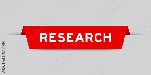 Red color inserted label with word research on gray background