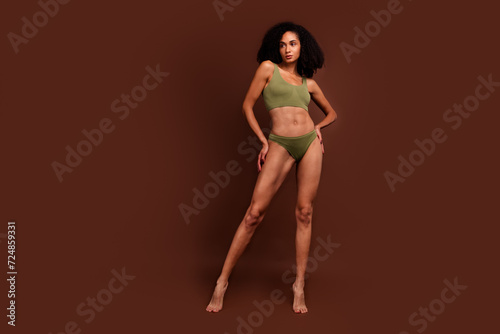 No filter full length photo of stunning sporty girl posing fashion collection top panties empty space isolated on brown color background