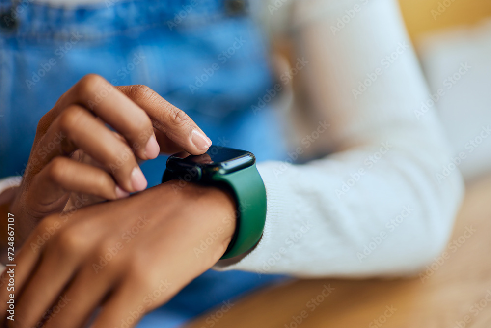 Close-up of a black female using a smartwatch, wearing around the wrist. - obrazy, fototapety, plakaty 