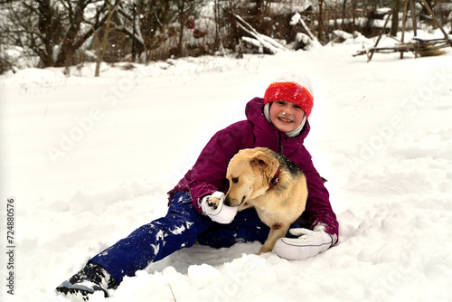 Obraz na płótnie A pet dog cuddles up to a girl in the snow in winter w salonie