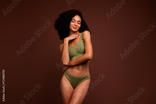 No retouch photo of perfect slim girl with close eyes posing in comfortable underwear collection isolated on brown color background © deagreez