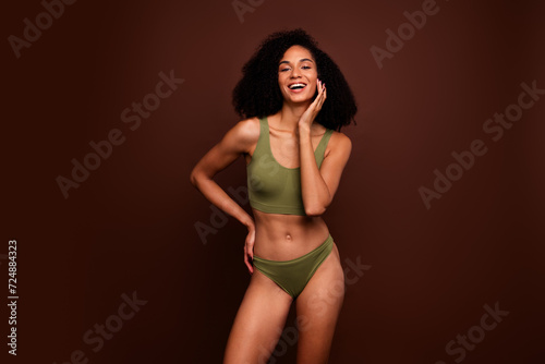 Studio no retouch photo of excited positive lady dressed lingerie accepting herself empty space isolated brown color background © deagreez