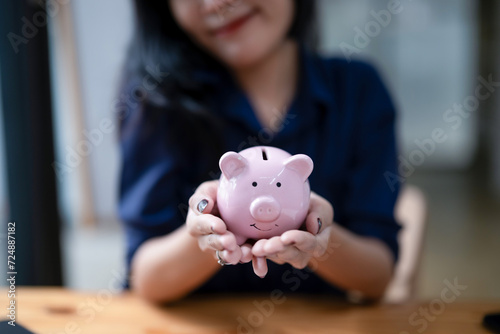 A female's hands holding a piggy bank. Saving money, financial