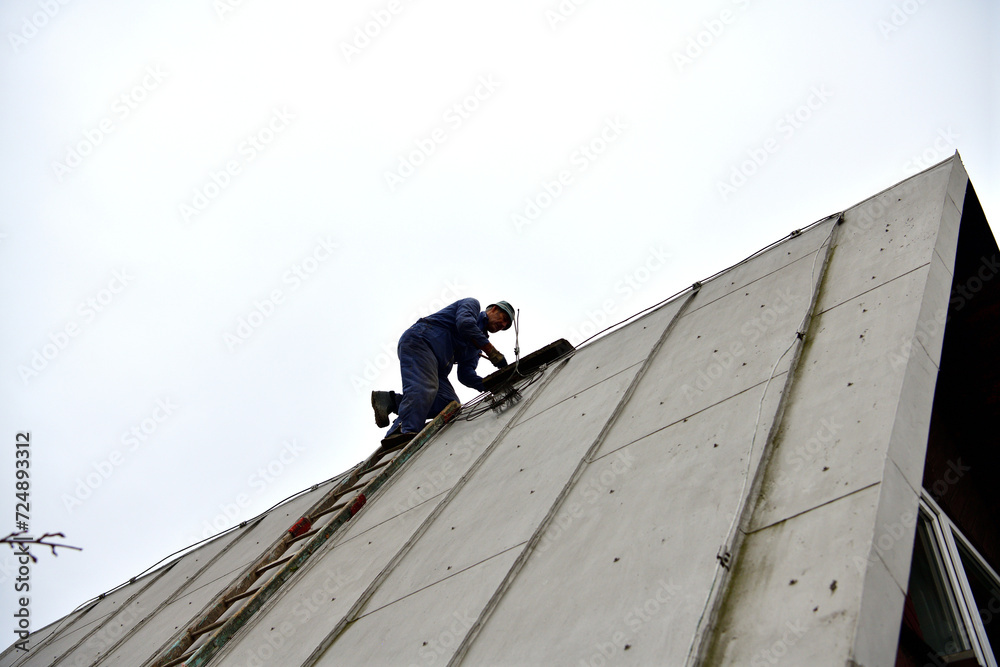 A chimneyer climbs a ladder to the roof to repair a chimney