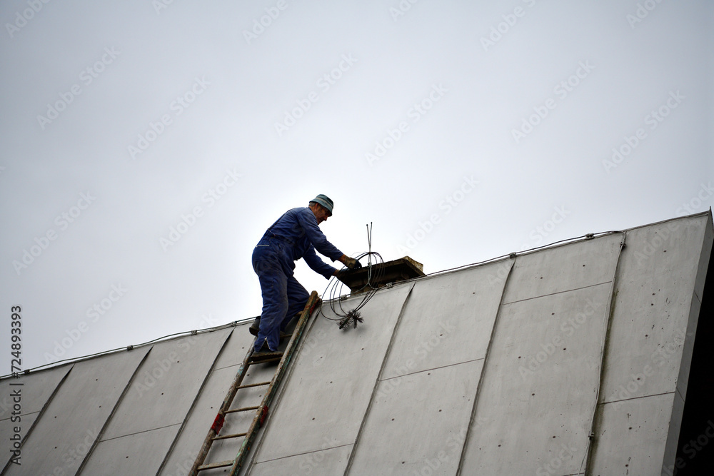 A chimneyer climbs a ladder to the roof to repair a chimney