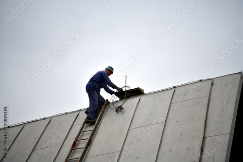 Obraz na płótnie A chimneyer climbs a ladder to the roof to repair a chimney w salonie