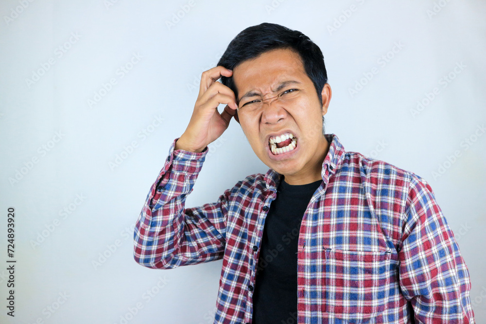 funny facial expression of stressed asian man holding his head, isolated on white background funny facial expression of stressed asian man holding his head, isolated on white background