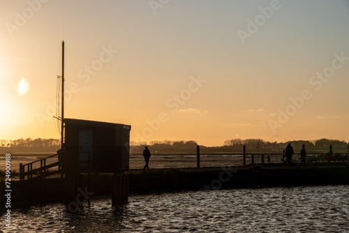 wooden observation bird hide on brick stilts at Emsworth at sunset with orange coloured sky in the background photo