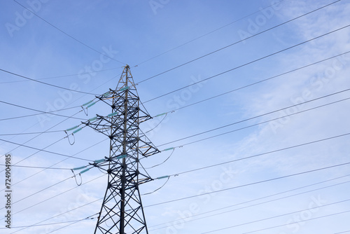 Bild auf Leinwand A high-voltage mast with wires against a clear blue sky