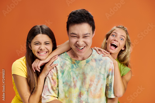 joyful interracial teenagers in casual attires looking at camera and having fun  friendship day
