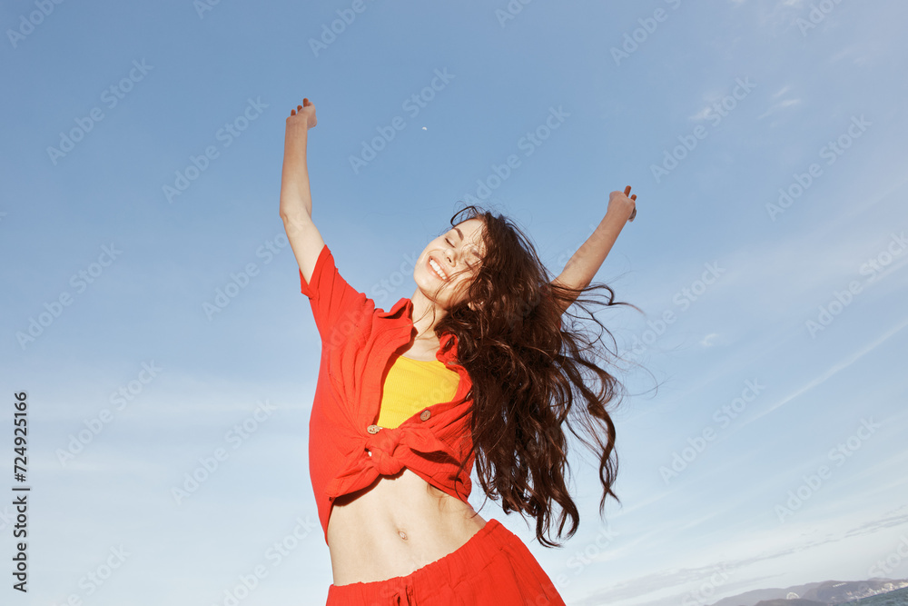 Dancing by the Sea: A Joyful Summer Portrait of a Beautiful, Smiling Woman in Trendy Red Clothes