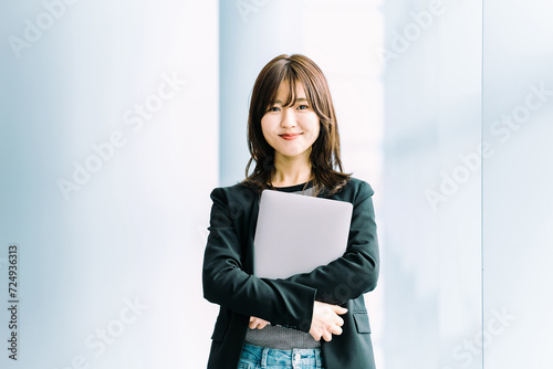 ノートパソコンを持つビジネスウーマン, Smiling Japanese woman holding a laptop computer