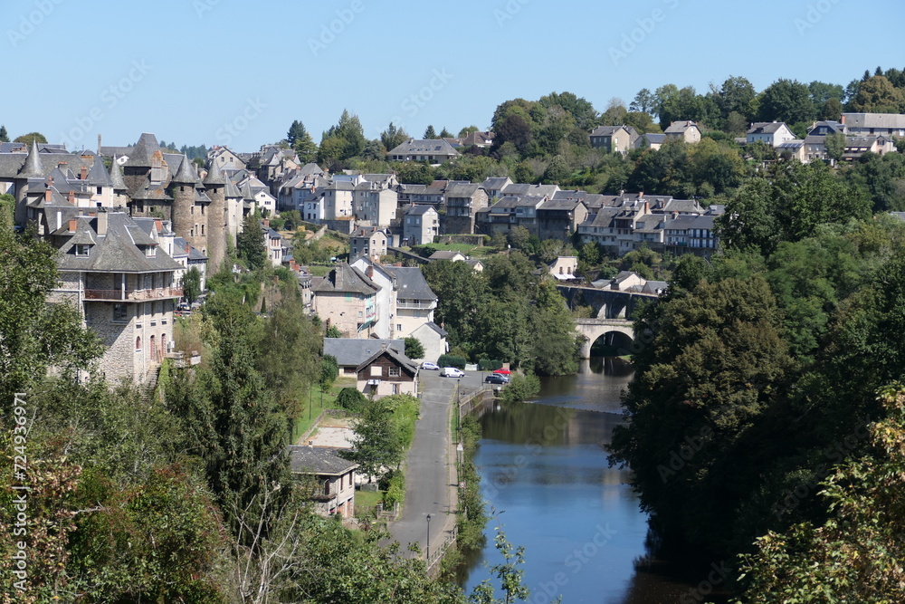 Uzerche, a picturesque French city, graces the hillside with its timeless charm during the summer. The city view reveals a tapestry of old buildings adorned with architectural elegance.