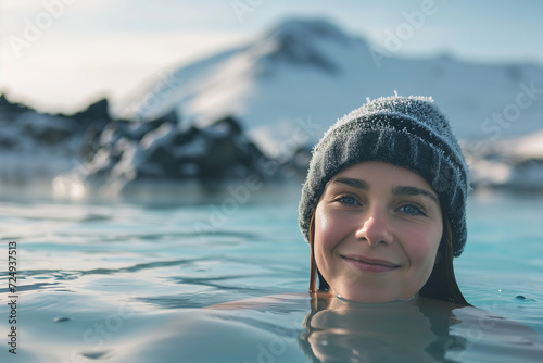 Young woman enjoying spa in hot springs in Iceland. Beautiful girl having fun in thermal bath on a backdrop of scenic Icelandic nature. © MNStudio