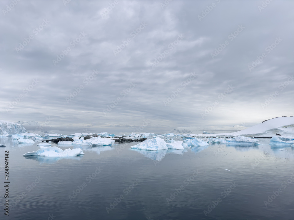 A huge high breakaway glacier in the southern ocean off the coast of Antarctica, the Antarctic Peninsula, the Southern Arctic Circle, azure water, cloudy weather A huge high breakaway glacier in the southern ocean off the coast of Antarctica, the Antarctic Peninsula, the Southern Arctic Circle, azure water, cloudy weather