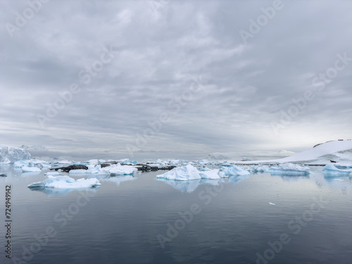 A huge high breakaway glacier in the southern ocean off the coast of Antarctica, the Antarctic Peninsula, the Southern Arctic Circle, azure water, cloudy weather