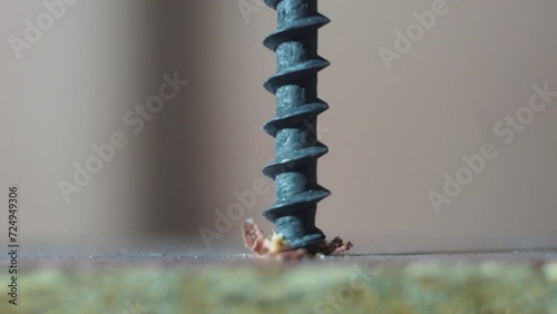A metal screw is screwed into a surface, close-up