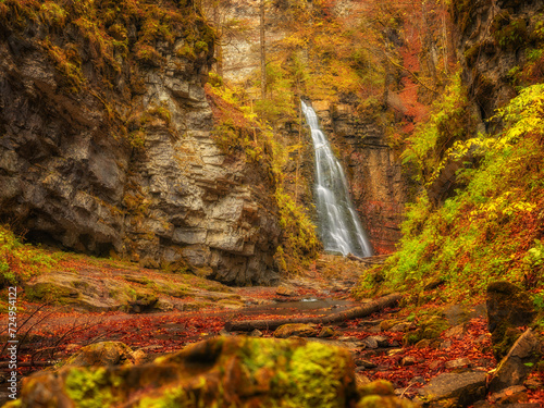 autumn in canyon with waterfall and red leaves © sergejson